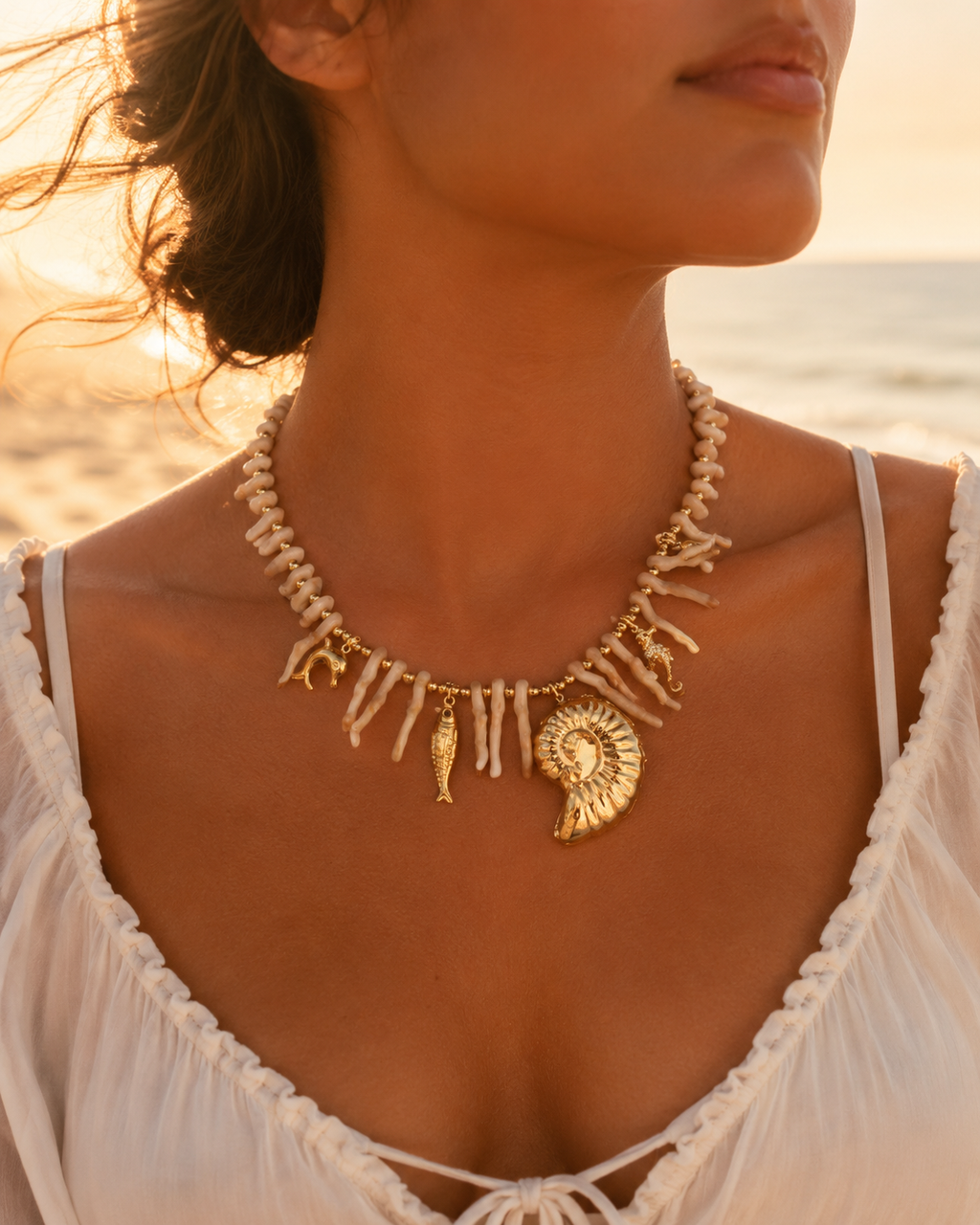 Ketting met naturel koraal details, goudkleurige bedels en stainless steel afwerking