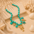 Ocean Charm Necklace Turquoise met turquoise kralen en goudkleurige oceaanbedels